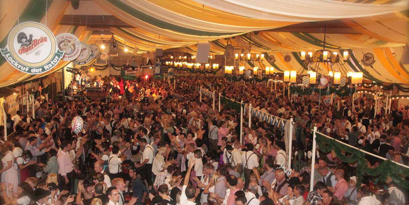 Tanzende Menschen bei bester Bierzeltstimmung im Auerbräu Festzelt.