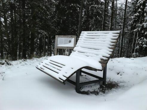 Liegebank mit Infotafel auf der Traischel im Winter