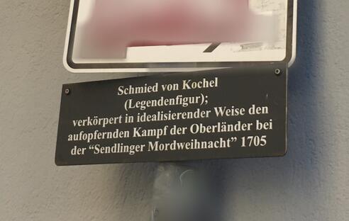 Eine Zusatztafel, die über den Schmied von Kochel informiert