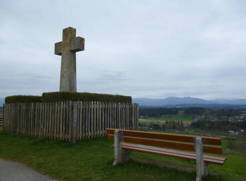 Markantes Steinkreuz auf dem Kreuzbichel - von den Bänken bietet sich ein schöner Blick über Oberhausen hinweg auf die Alpenkette.