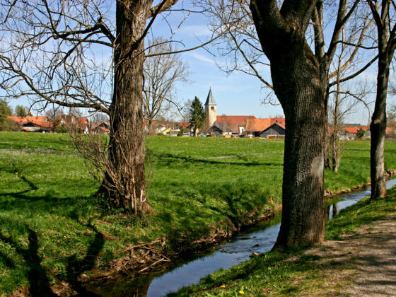 Die Peitnach mit der Kirche St. Michael von Peiting im Hintergrund