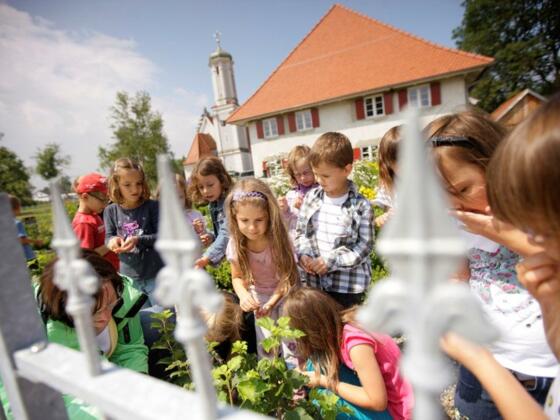 Kräutergarten und im Hintergrund das Mesnerhaus