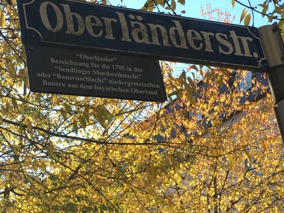 Das Straßenschild der Oberländerstraße in München mit Zusatztafel