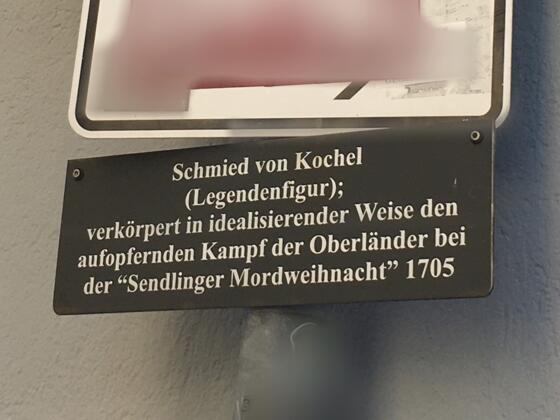 Eine Zusatztafel, die über den Schmied von Kochel informiert