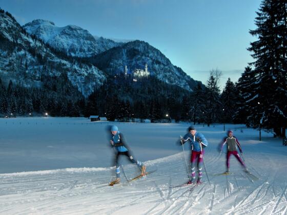 Flutlicht-Langlauf vor der Kulisse von Säuling und Schloß Neuschwanstein