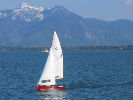Segelboot auf dem Chiemsee vor toller Alpenkulisse.