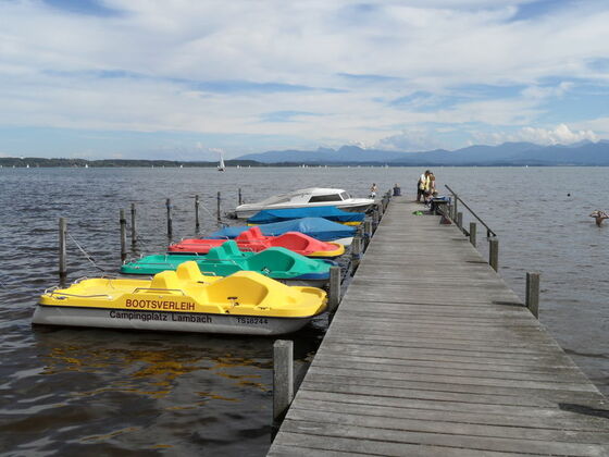 Steg in den Chiemsee mit Booten.