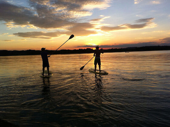 Stand-Up Paddeln am Chiemsee bei Sonnenuntergang.