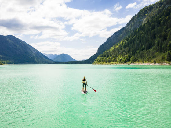 Fjordartiger Sylvensteinsee mit SUP-Paddler