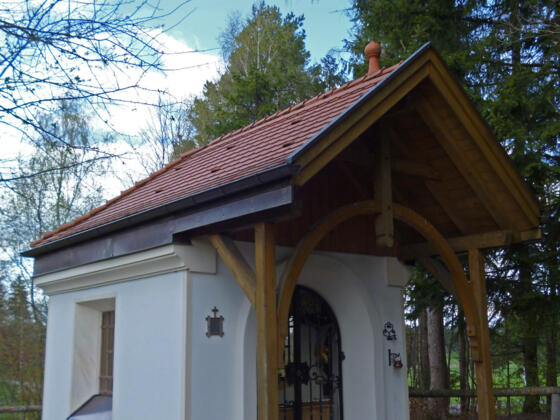 Die Marienkapelle am Wolfbichl liegt gut versteckt hinter Bäumen.