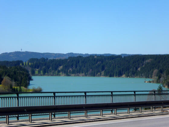 Blick von der Lechtalbrücke über den türkis leuchtenden Lech zum Fernmeldeturm auf dem Tannenberg.