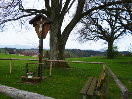 Wegkreuz mit Bank oberhalb von Huglfing.