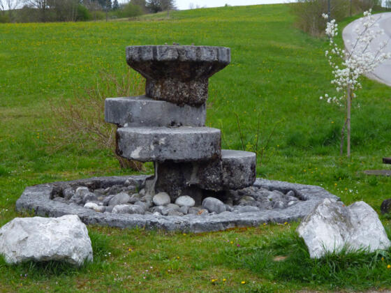 Tuffstein-Brunnen auf der Ostseite des Huglfinger Bahnhofs.