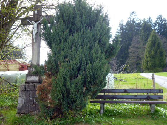 Wegkreuz mit Bank an der Straße zwischen Schnalz und Holzleithen.