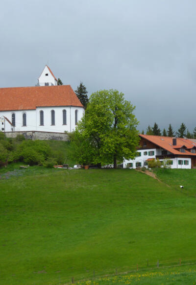 Die Kirche St. Georg und der wenig unterhalb gelegene Panorama-Gasthof auf dem Auerberg.