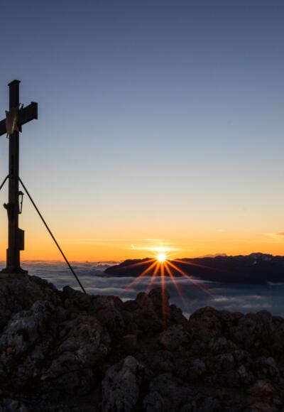 Die Sonne spitzt über dem Untersberg hervor.
