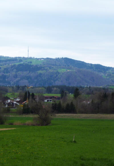 Blick über die Häuser von Obermaxlried hinweg zum Hohen Peißenberg.
