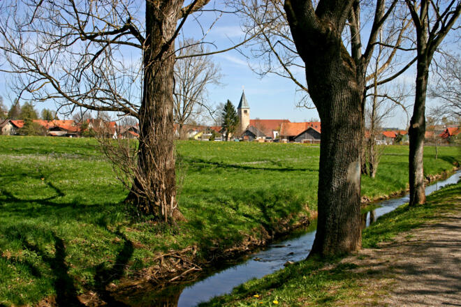 Die Peitnach mit der Kirche St. Michael von Peiting im Hintergrund