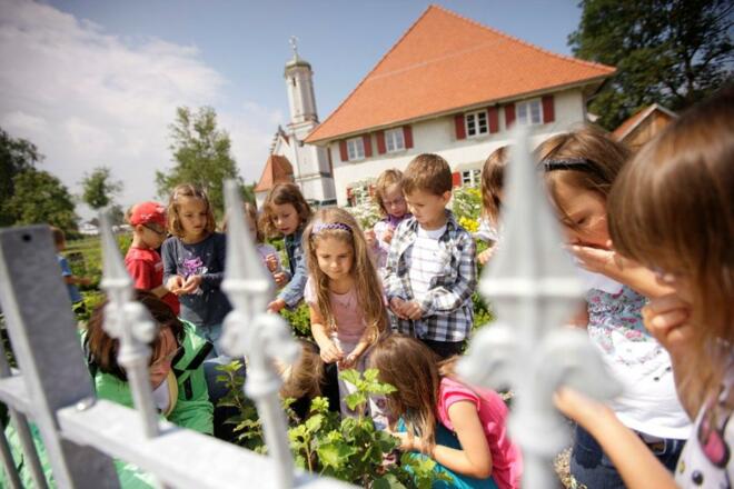 Kräutergarten und im Hintergrund das Mesnerhaus