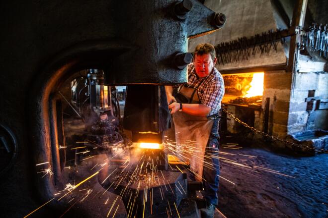 Bei Schmiedevorführungen fliegen im Eisenhammer die Funken