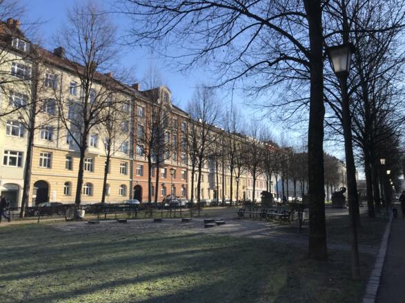Blick auf den grünen Bordeauxplatz mit Sitzgelegenheiten