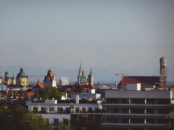 Die Münchner Frauenkirche vor Alpenpanorama