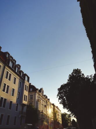Abendlicht spiegelt sich im Fenster eines Hauses