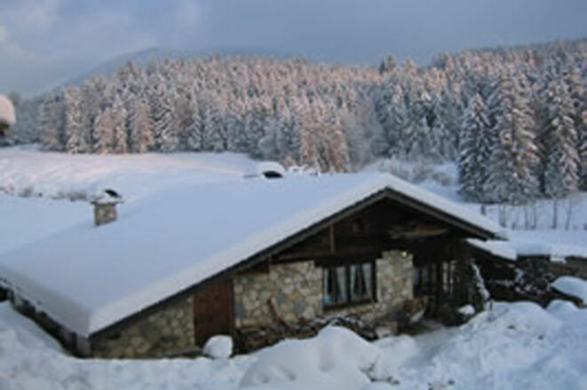 Verschneite Almhütte im Skigebiet Samerberg.