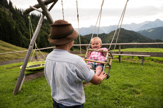 Kinder beim Schaukeln auf dem Spielplatz Alpe Osterberg