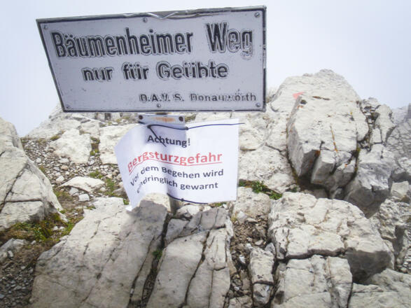 Das Ende des Bäumenheimer Weg und kurz vor dem Gipfel. Der Warnhinweis wegen Bergsturz ist zu beachten.