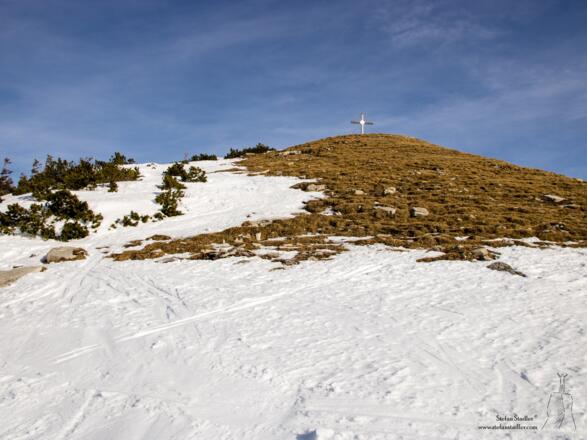Plötzlich erscheint das Gipfekreuz des Hohen Zinken am Horizont.