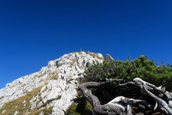 Nach der Scharte klettert man ein wenig ausgesetzt das letzte Stück zum Gipfelkreuz hoch
