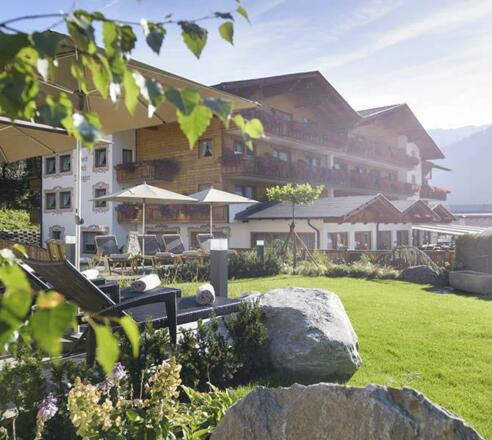 Hotel-Brugger-Aussenansicht-Garten-Sonnenliegen