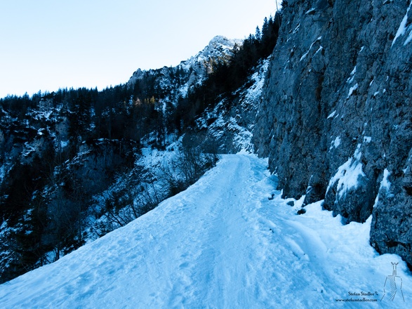 An einer Felswand vorbei immer auf dem Wirtschaftsweg nach oben.