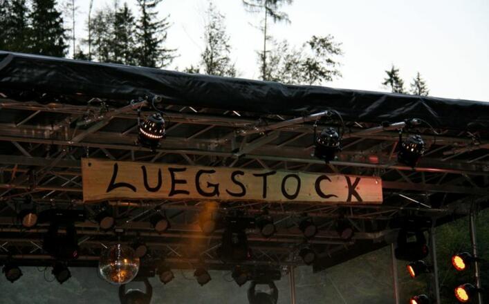 Holzbrett an der Bühne mit der Aufschrift Luegstock.