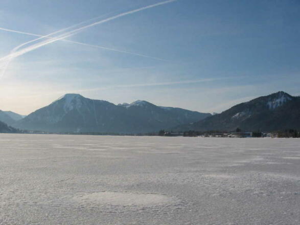 Blick vom See mit Eisdecke zum Wallberg