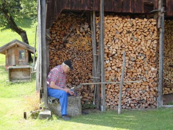 Der Opa beim dengeln der Sense