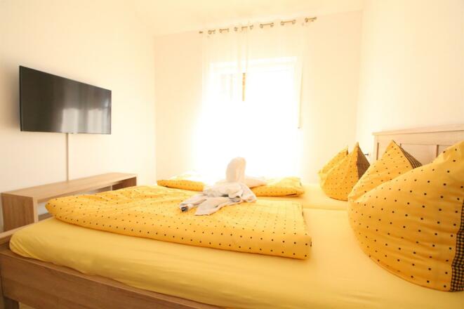 Sonniges Schlafzimmer mit Doppelbett &amp; Smart TV