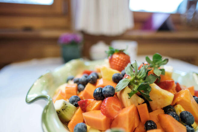 Frühstücksbuffet mit frischem Obstsalat und regionalen Spezialitäten