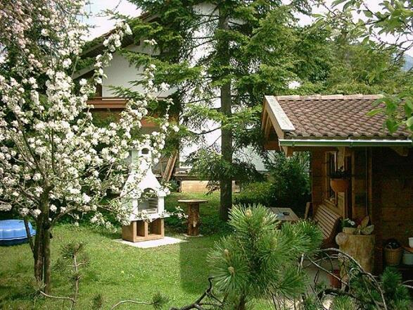 Garten im Frühjahr mit Grillplatz und Blockhaus