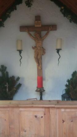 Das Altarkreuz, geschmückt von zwei Kerzenleuchtern.