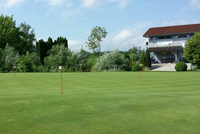 Golfplatz mit Clubhaus im Hintergrund.