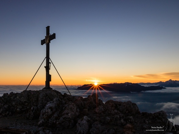 Die Sonne spitzt über dem Untersberg hervor.