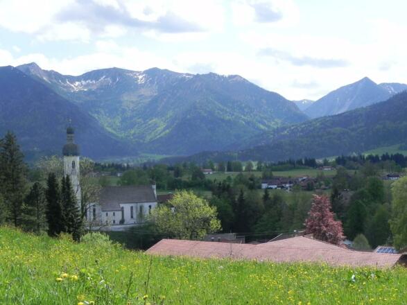 Blick oberhalb von Elbach auf die Kirche Elbach und Berge