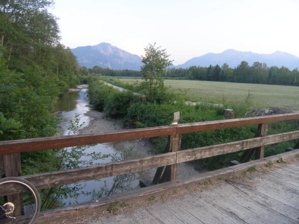 Eine Holzbrücke überspannt den Lainbach. 