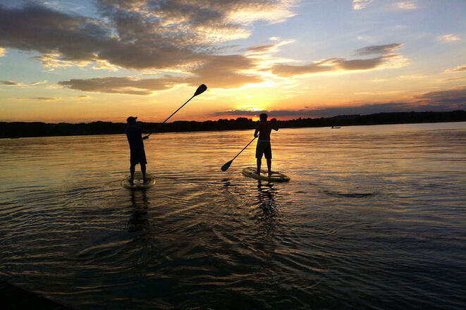 Stand-Up Paddeln am Chiemsee bei Sonnenuntergang.