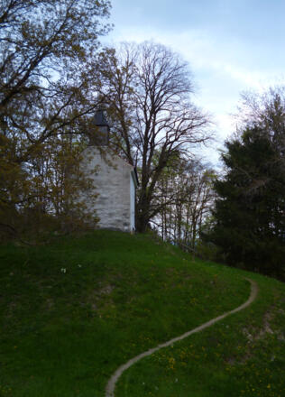Ein schmaler, gepflasterer Stichweg führt zur St. Georg Kapelle oberhalb von Peißenberg.