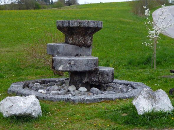 Tuffstein-Brunnen auf der Ostseite des Huglfinger Bahnhofs.