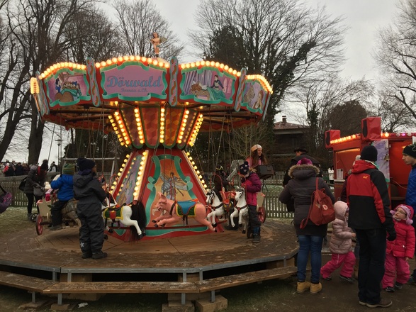 Kinder haben Freude mit dem Karussell.