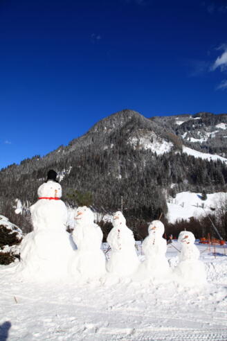 Schneemannfamilie am Weg